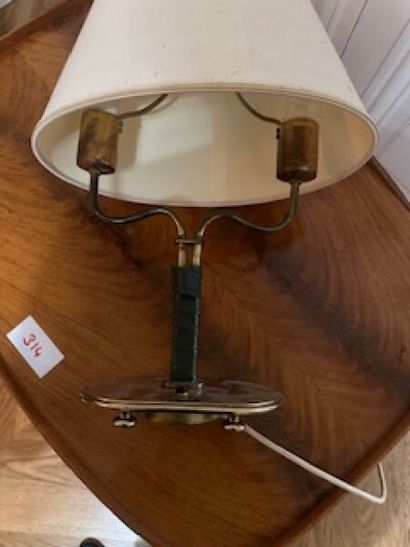 1 two-arm brass table lamp on oval base resting...