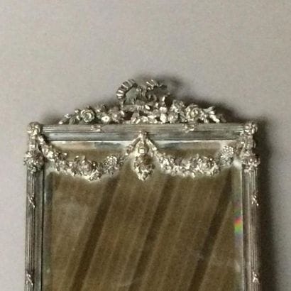 Miroir de dame en bronze argenté.
La partie...
