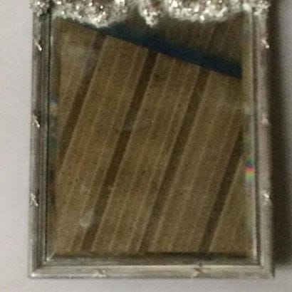 Miroir de dame en bronze argenté.
La partie...