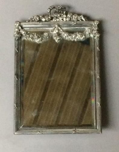 Miroir de dame en bronze argenté.
La partie...