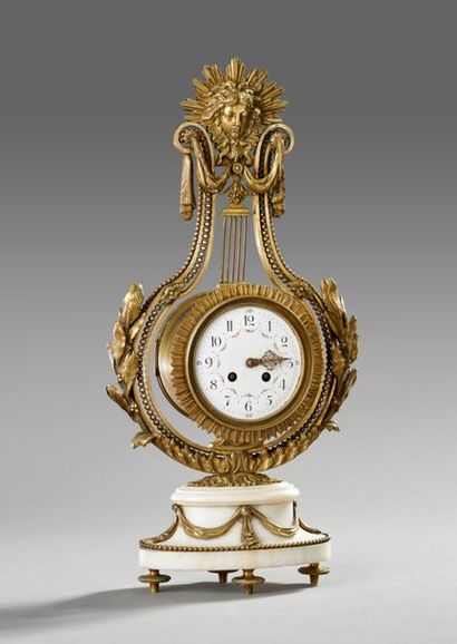 Pendule de forme lyre en bronze doré et ciselé.
La...