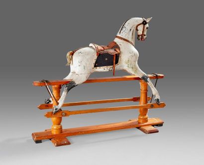 Curieux cheval à bascule en bois sculpté...