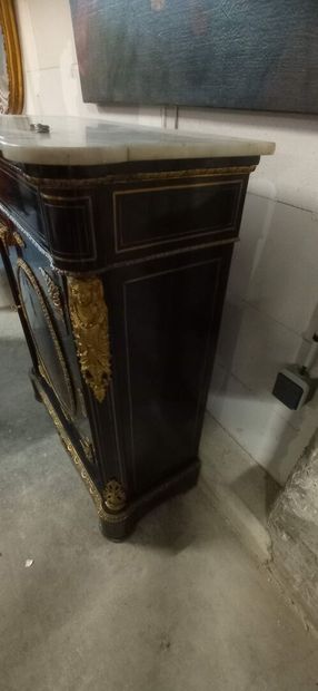 Meuble à hauteur d'appui en bois noirci.

Ouvre...