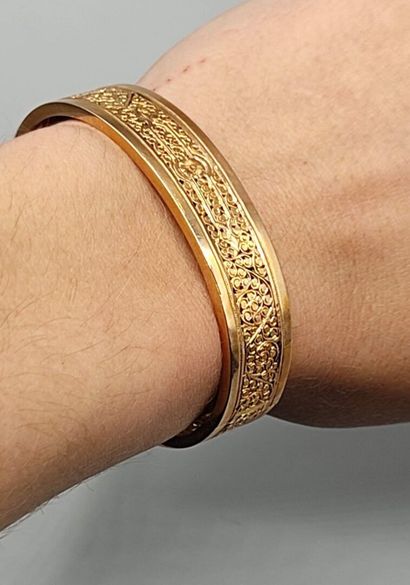 Bracelet rigide en or 750°° orné de motifs...