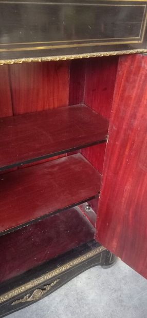 Meuble à hauteur d'appui en bois noirci.

Ouvre...