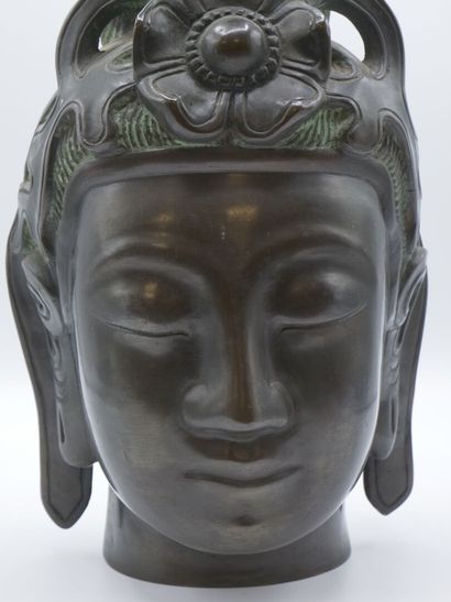 Curieuse tête de divinité en bronze patiné.

Pose...
