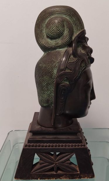 Curieuse tête de divinité en bronze patiné.

Pose...