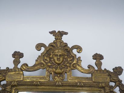 Miroir en bronze patiné.

Décor de tête feuillagée...