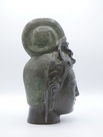 Curieuse tête de divinité en bronze patiné.

Pose...