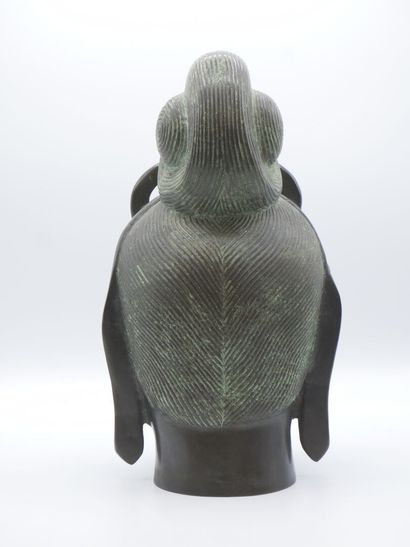 Curieuse tête de divinité en bronze patiné.

Pose...
