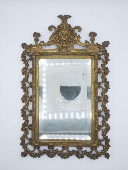 Miroir en bronze patiné.

Décor de tête feuillagée...