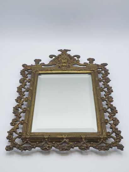 Miroir en bronze patiné.

Décor de tête feuillagée...