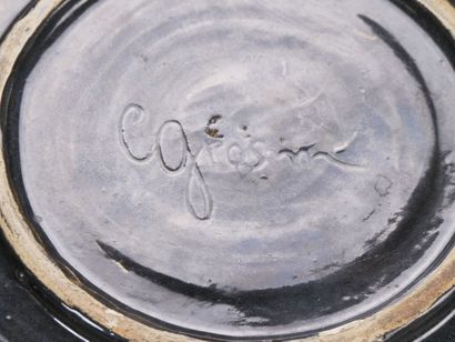 Plat en céramique sur fond noir à décor émaillé...