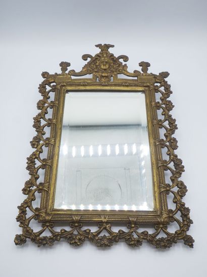 Miroir en bronze patiné.

Décor de tête feuillagée...