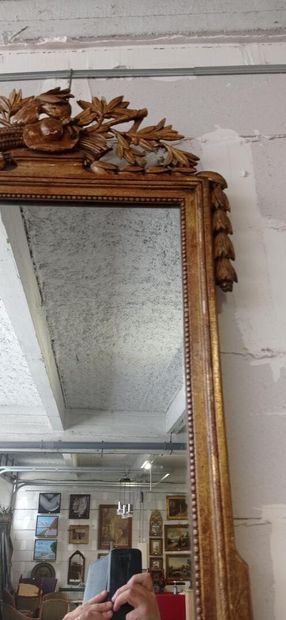 Mirror in gilded and carved wood decorated...
