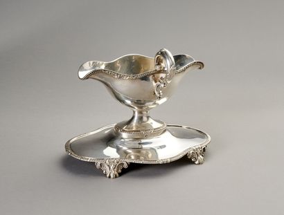 Sauceboat in silver on its polylobed display.

Decorated...