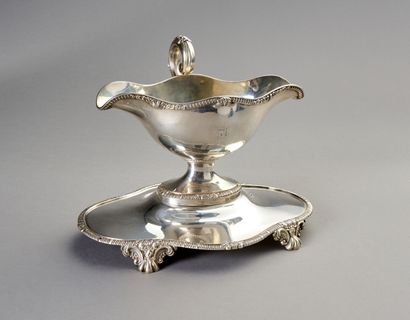 Sauceboat in silver on its polylobed display.

Decorated...