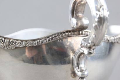 Sauceboat in silver on its polylobed display.

Decorated...