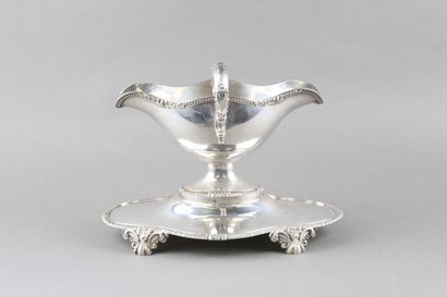 Sauceboat in silver on its polylobed display.

Decorated...