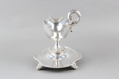 Sauceboat in silver on its polylobed display.

Decorated...