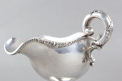 Sauceboat in silver on its polylobed display.

Decorated...