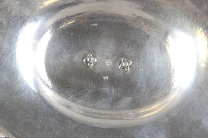 Sauceboat in silver on its polylobed display.

Decorated...