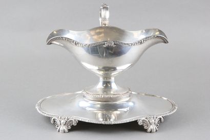 Sauceboat in silver on its polylobed display.

Decorated...
