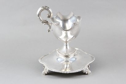 Sauceboat in silver on its polylobed display.

Decorated...