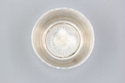 CHRISTOFLE
Silver tumbler resting on a large...