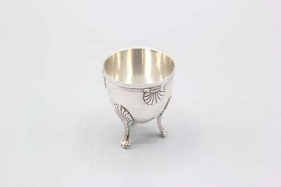 Coquetier tripode en argent à décor de coquilles....