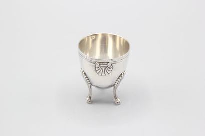 Coquetier tripode en argent à décor de coquilles....