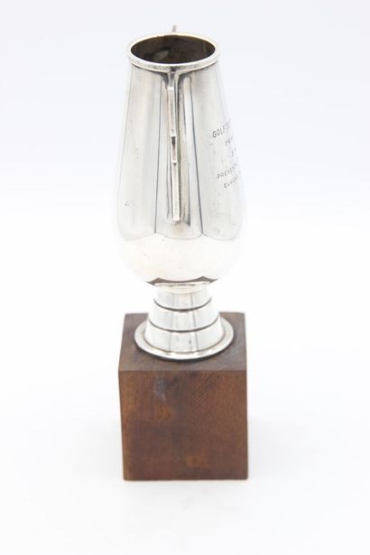 Silver golf cup.
Stylized handle.
It is inscribed...
