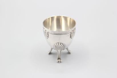 Coquetier tripode en argent à décor de coquilles....