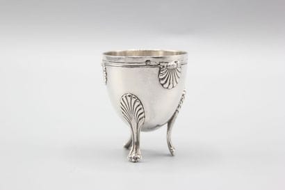 Coquetier tripode en argent à décor de coquilles....