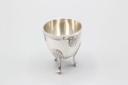 Coquetier tripode en argent à décor de coquilles....