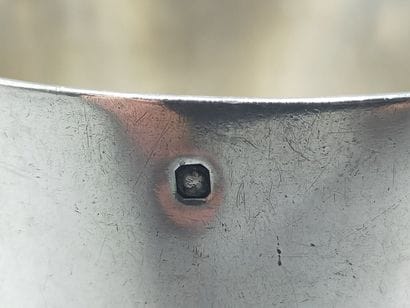 CHRISTOFLE
Silver tumbler resting on a large...