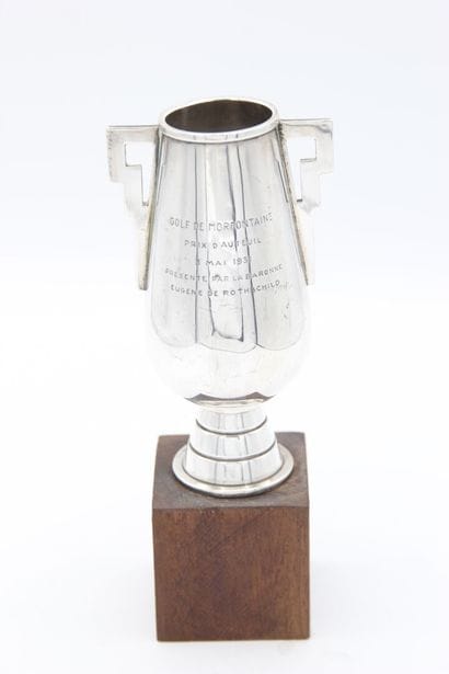 Silver golf cup.
Stylized handle.
It is inscribed...