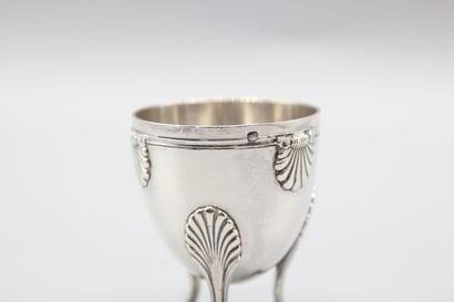 Coquetier tripode en argent à décor de coquilles....