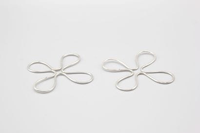 Pair of trivets. Silver bottle of form quarte-feuilles....