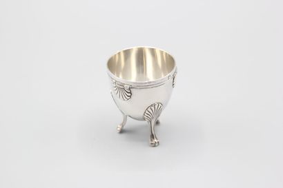 Coquetier tripode en argent à décor de coquilles....