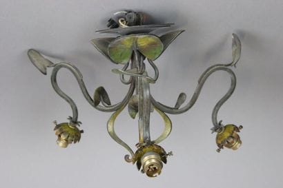 Lustre à trois feux en métal patiné.
Décor...