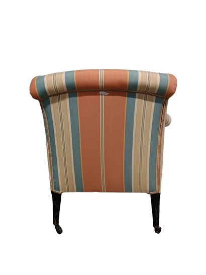 Fauteuil capitonné orné d'un tissu rayé.
Pose...