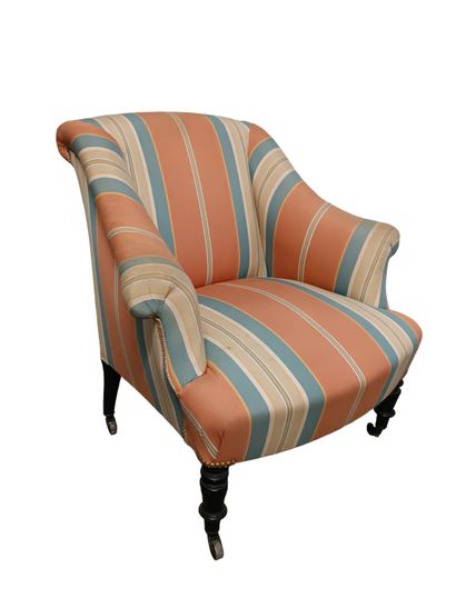 Fauteuil capitonné orné d'un tissu rayé.
Pose...