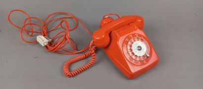 Téléphone vintage filaire de couleur orangée.
Cadran...