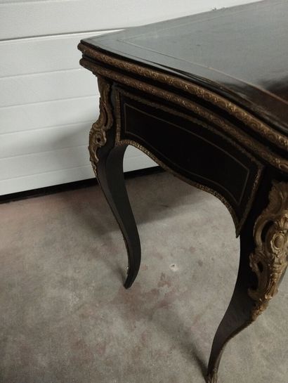 Table à jeux en bois noirci à plateau portefeuille.
Décor...