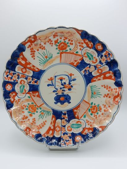 IMARI. 
Plat en porcelaine polychrome à bords...