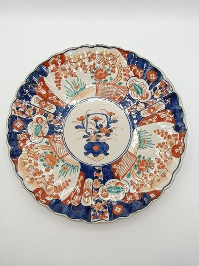 IMARI. 
Plat en porcelaine polychrome à bords...