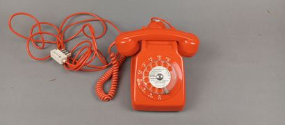 Téléphone vintage filaire de couleur orangée.
Cadran...
