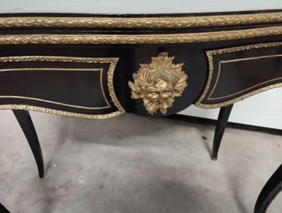Table à jeux en bois noirci à plateau portefeuille.
Décor...