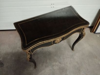Table à jeux en bois noirci à plateau portefeuille.
Décor...